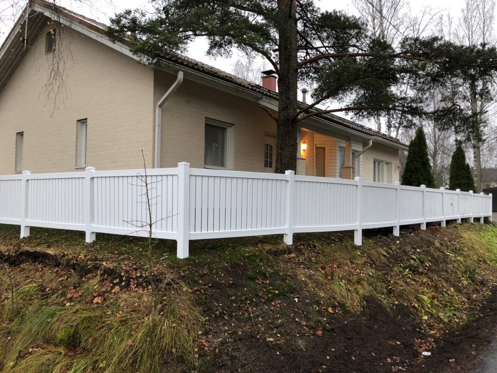 Valkoinen vinyyliaita vaalean talon ympärillä